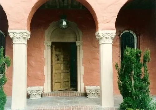A large wooden door in front of an archway.